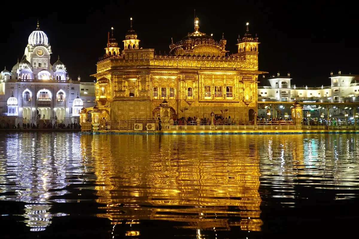 The Golden Temple reflected in the water at night
