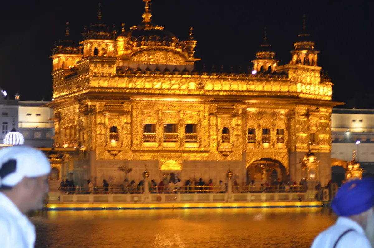 Pilgrims near the illuminated temple at night