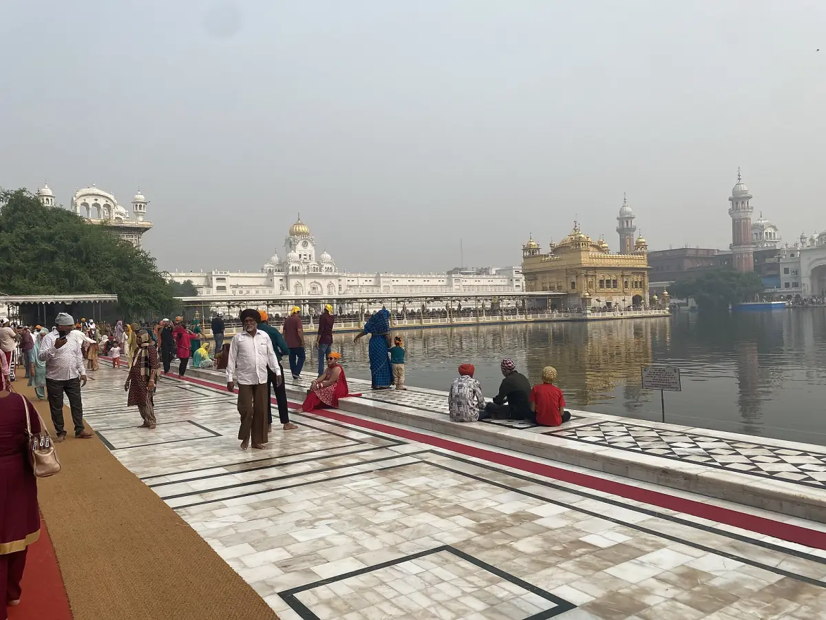 Pilgrims on the marble walkway around the pool